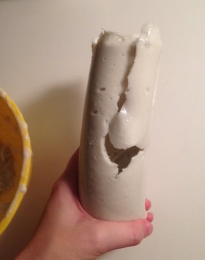 Holding up the broken and cracked mold from the first attempt at the DIY dildo.