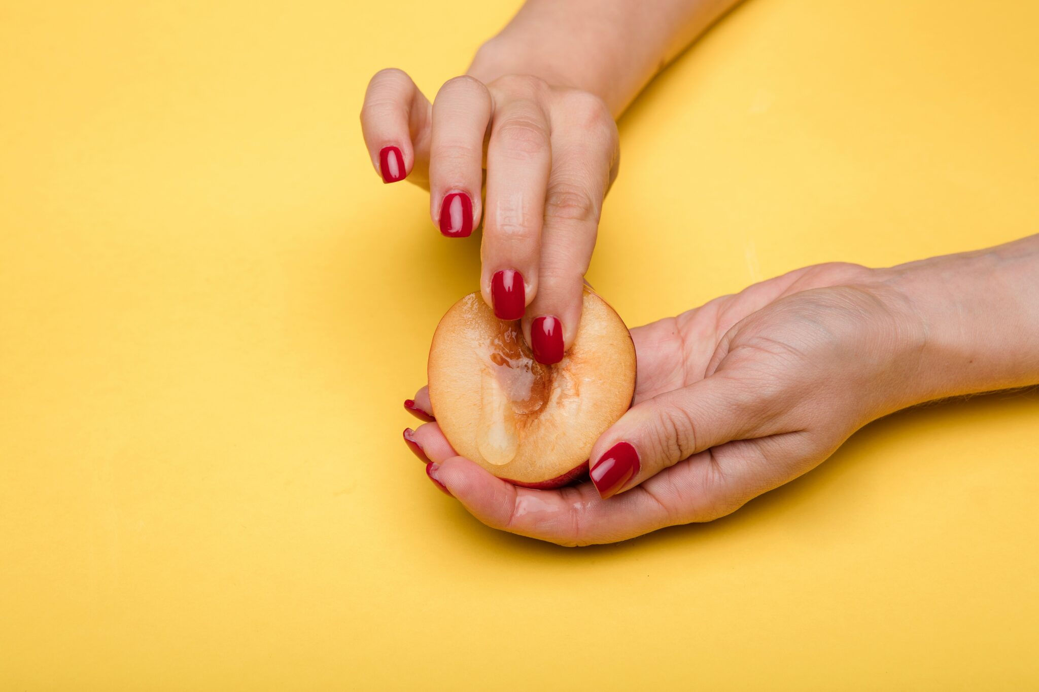 A woman's hands fingering a peach.