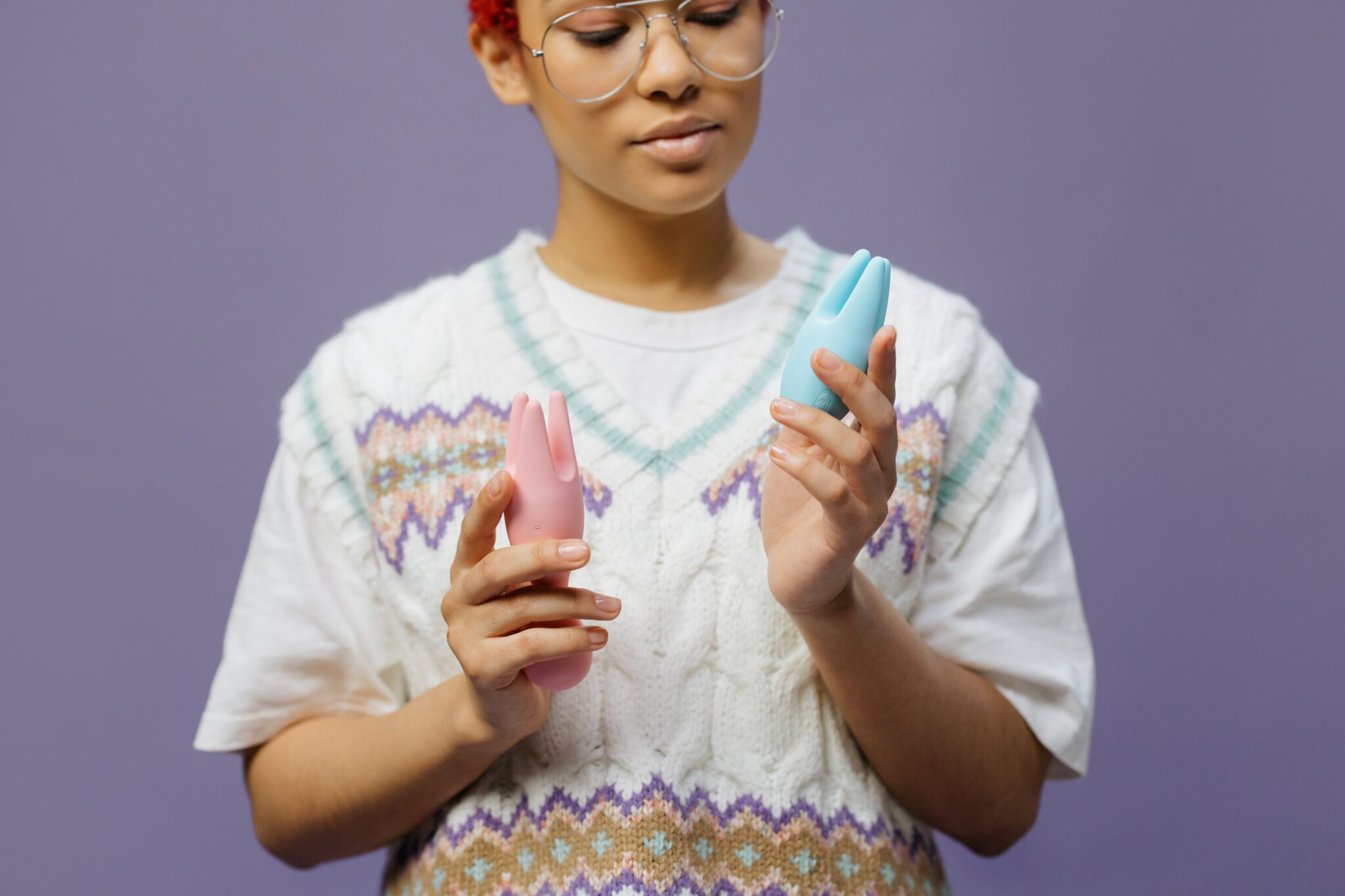 Woman holding up two different vibrators.