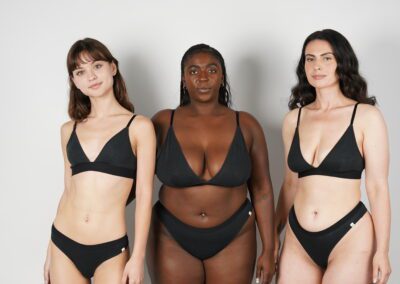 Three women wearing WAMA's black organic underwear.