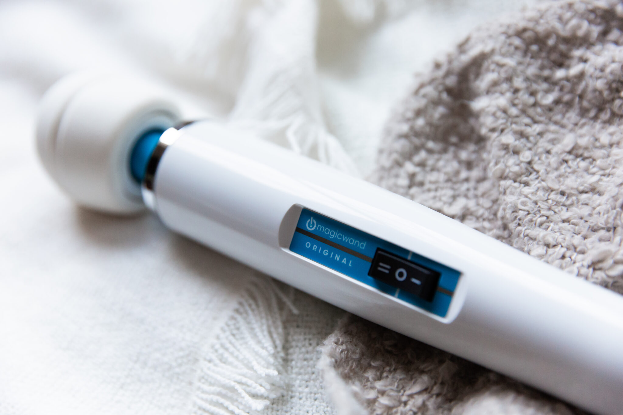 Image of the white-bodied Hitachi Magic Wand featuring its control switch and blue accents.