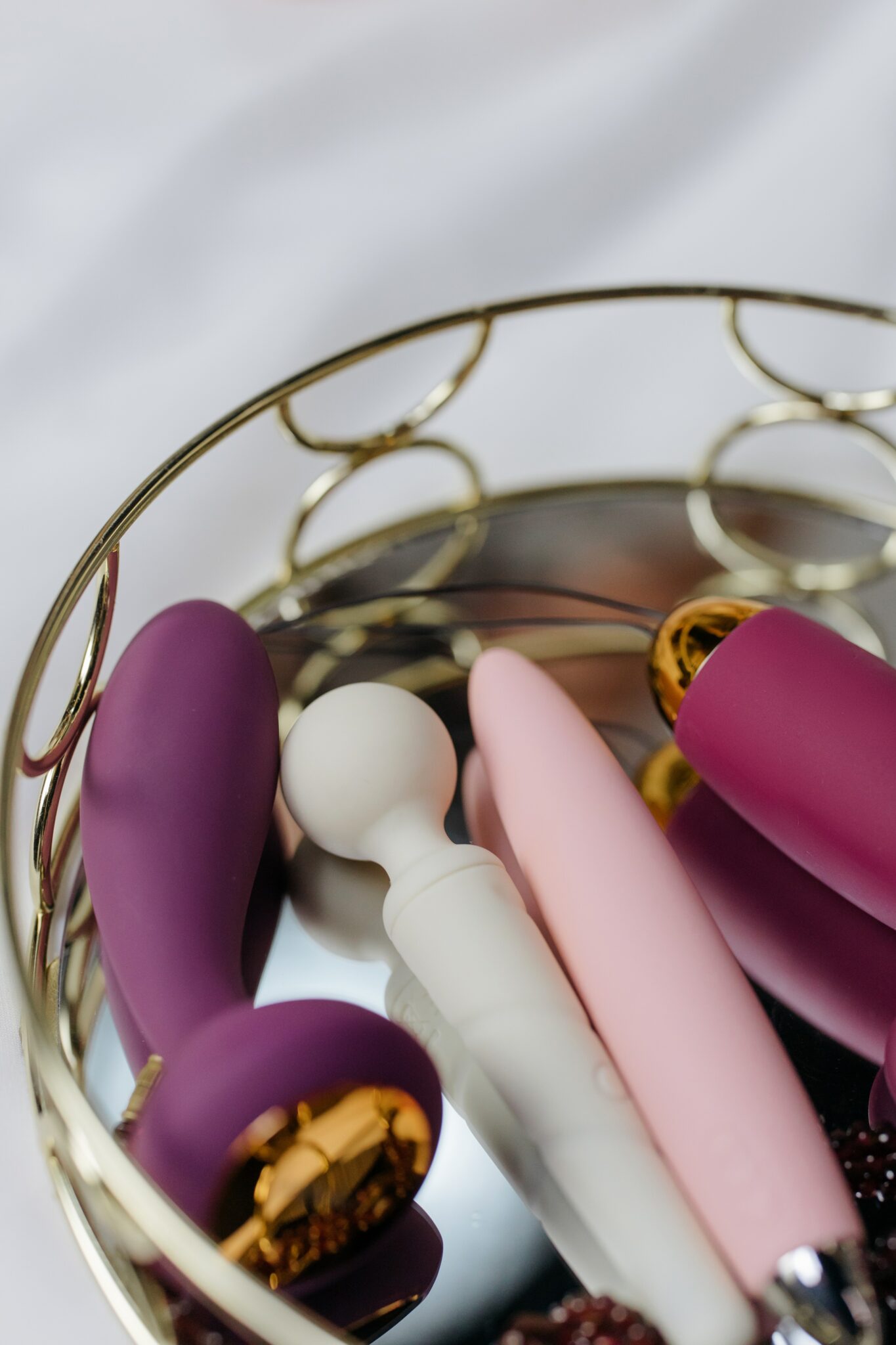 Four pink and purple sex toys in a tray.
