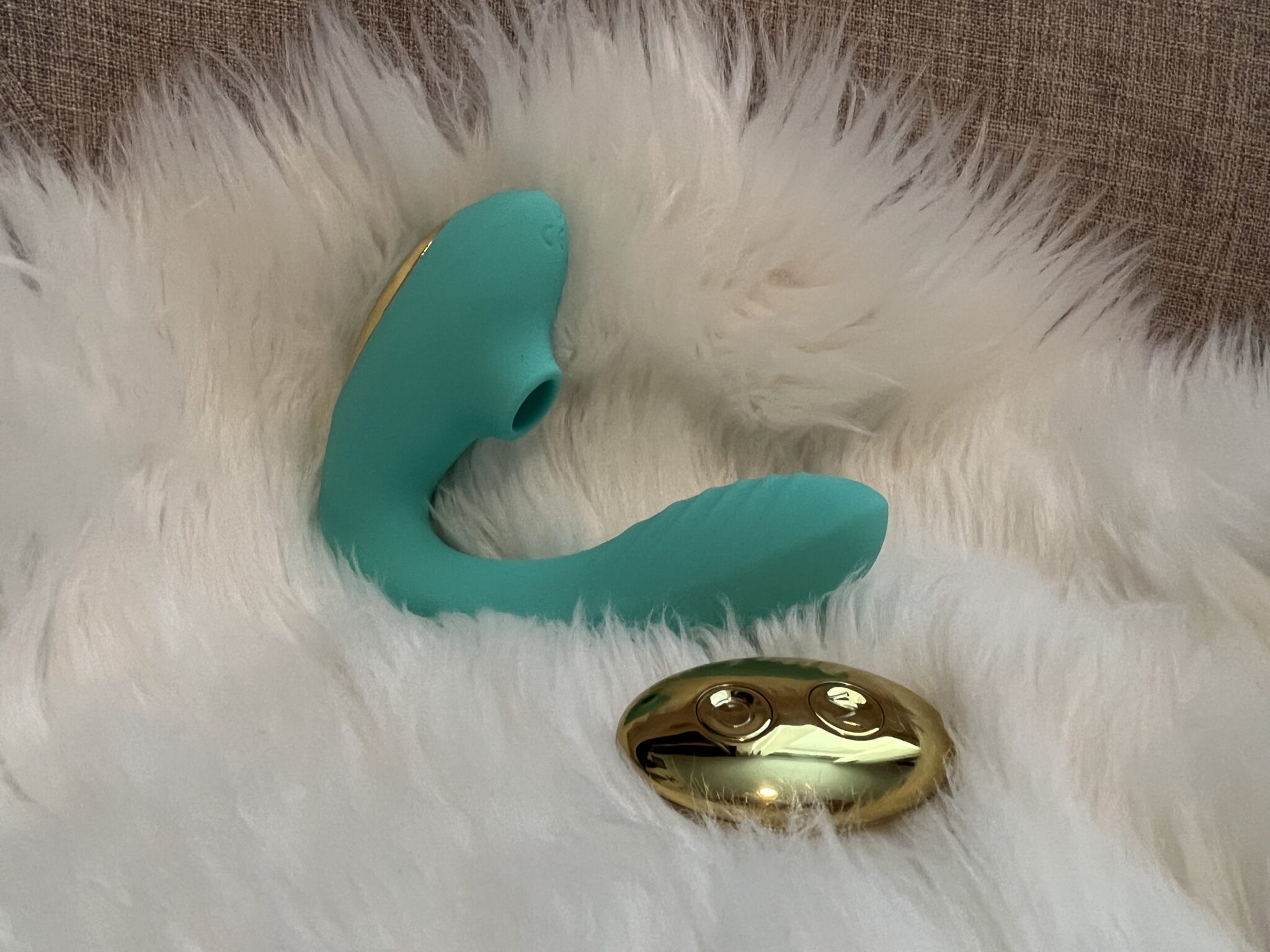 This teal and gold clitoral sucking vibrator curves to fit and vibrate within you while stimulating you from the outside.