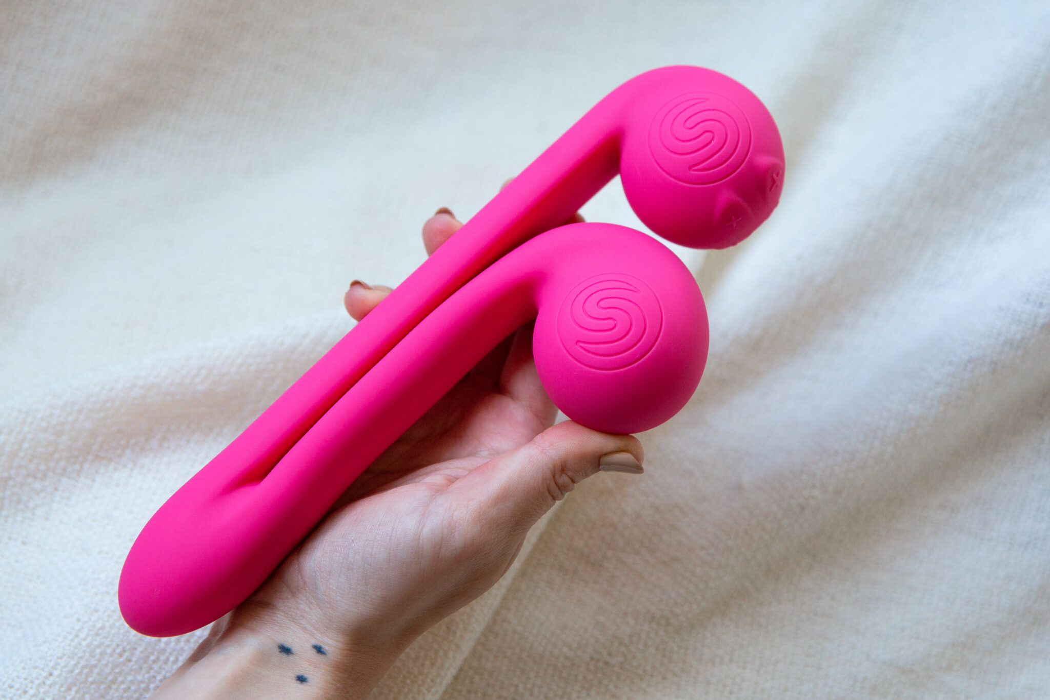 A woman's hand holding the pink and powerful rabbit vibrator.