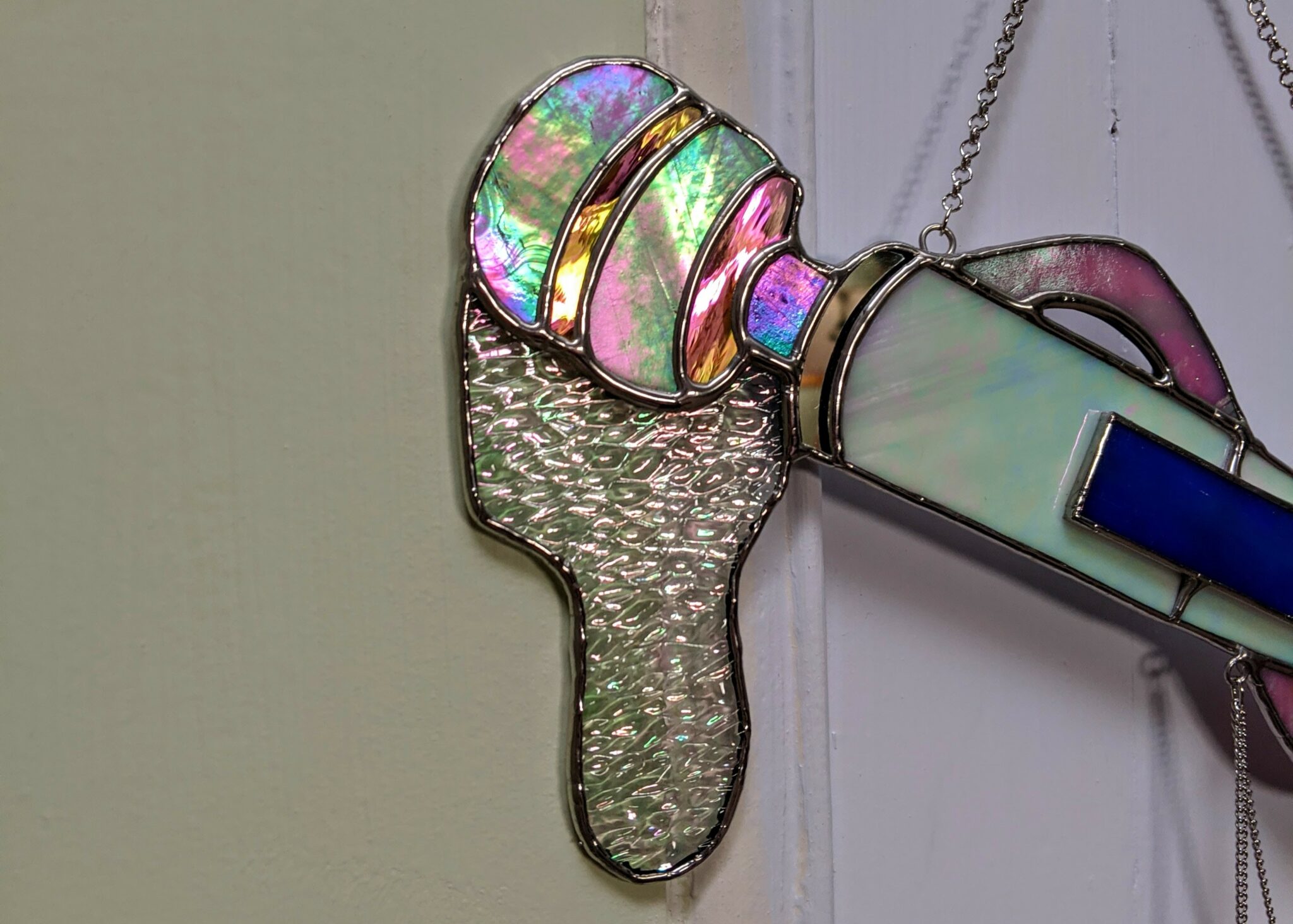 The head of the stained glass Magic Wand vibrator features a white glitter that appears to be dripping from the vibe.