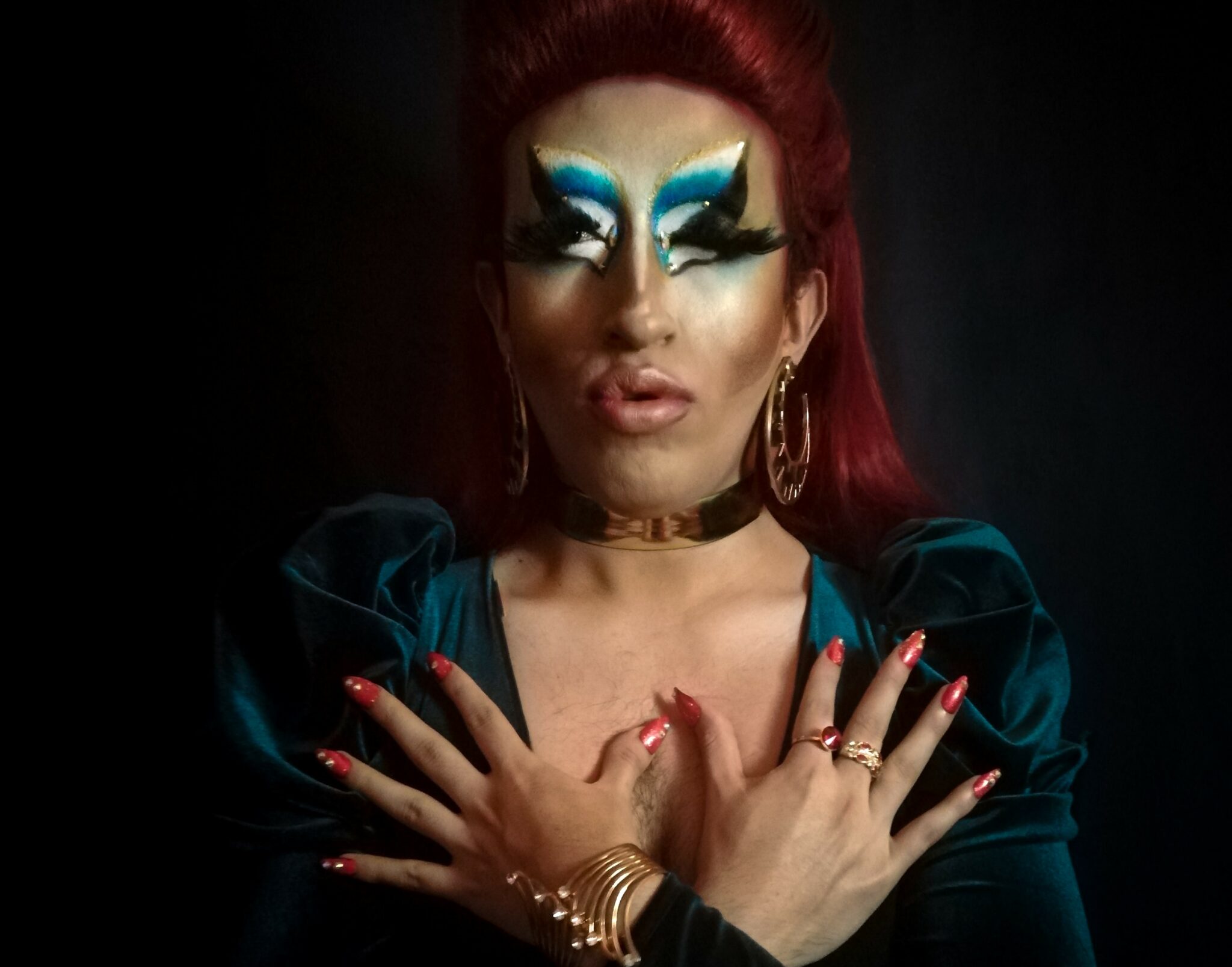 A drag queen wearing vibrant blue eye makeup.