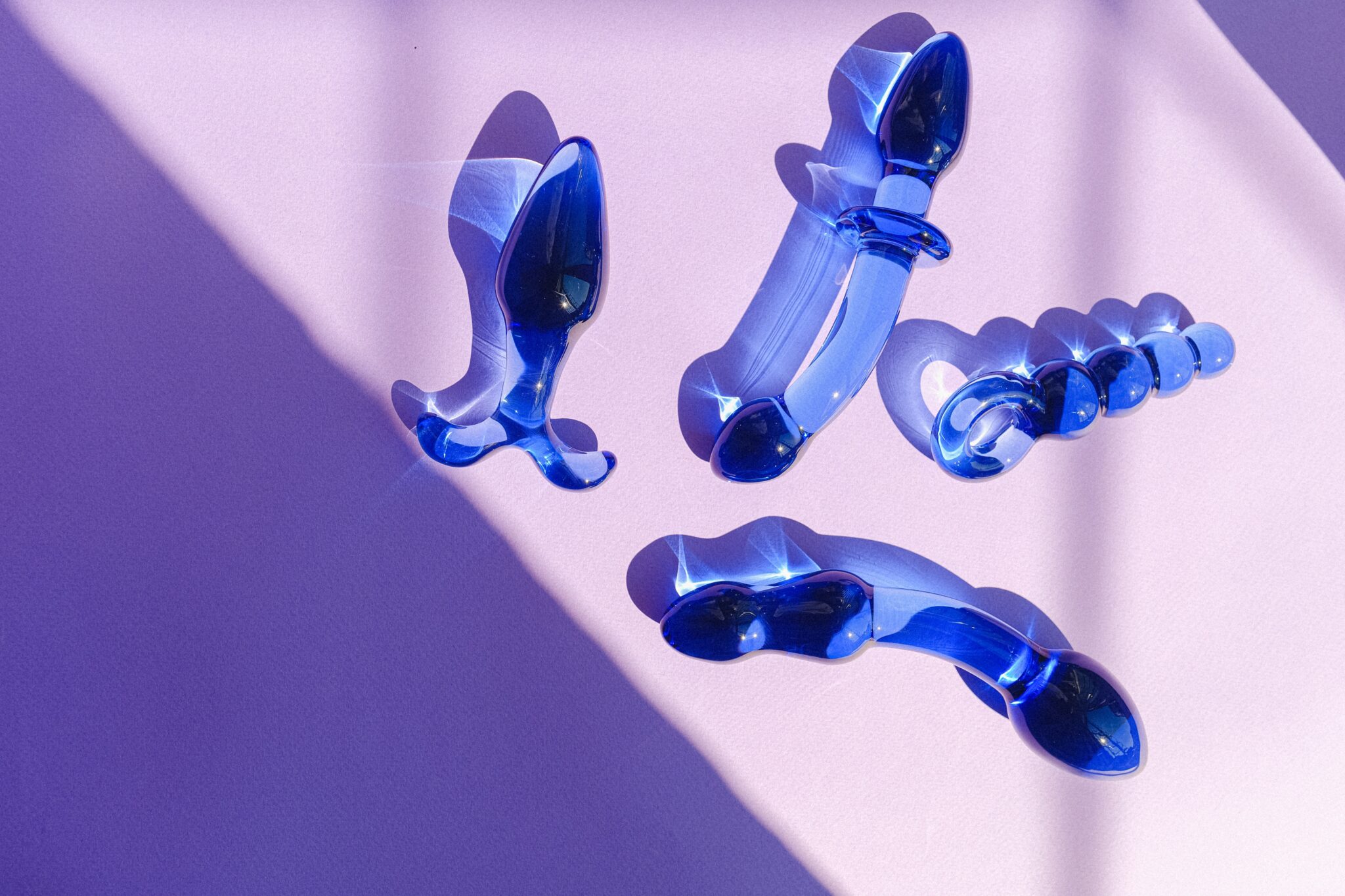 Blue glass anal toys reflecting sunlight.