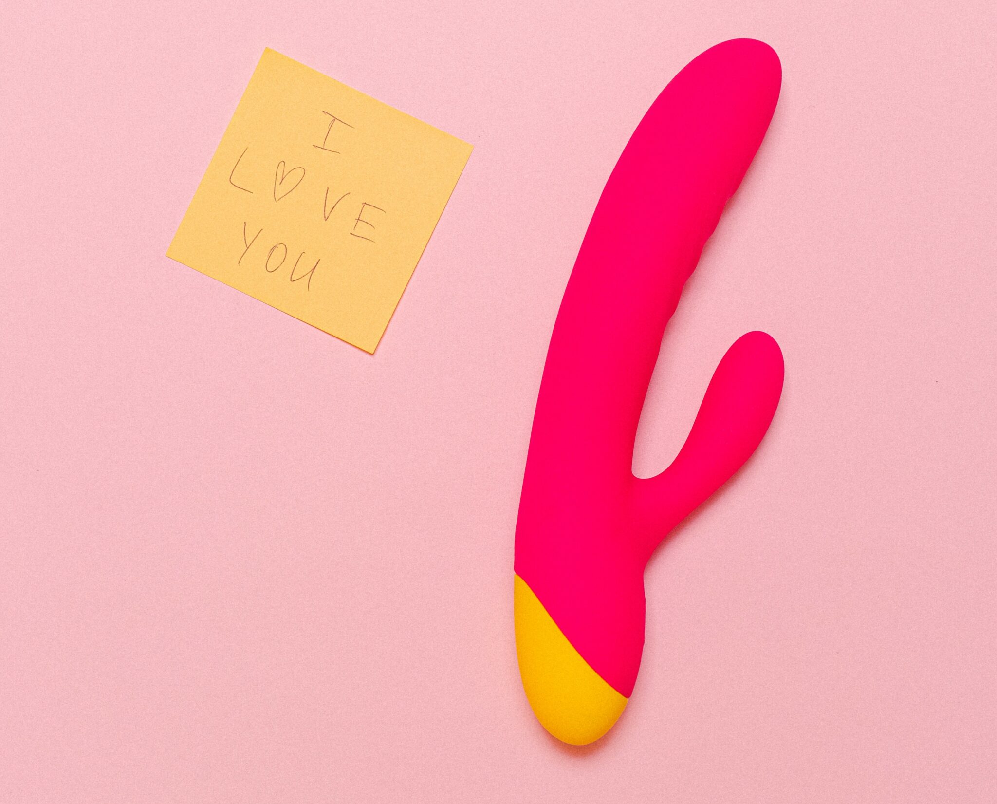 A pink vibrator beside a sticky note saying "I love you"