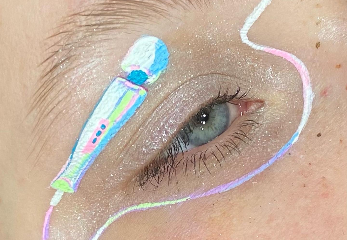 Eye makeup done by Megan Wirick featuring a white and luminescent Magic Wand painted across an eyelid.