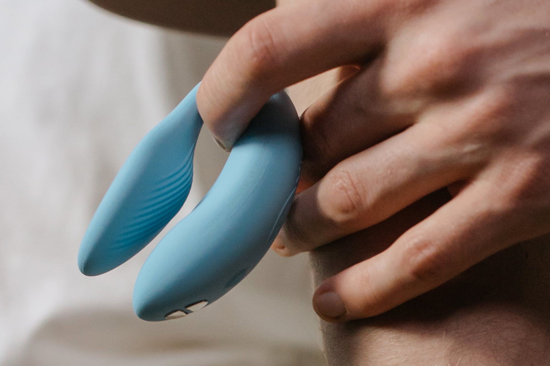 A person holding the We-Vibe Chorus in light blue